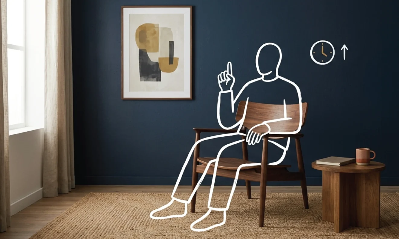An empty mid-century walnut armchair beside a low timber side table with a closed notebook and ceramic mug, set against a deep navy wall with a framed abstract artwork, with a white line illustration of a seated figure holding one finger raised as if working through a checklist